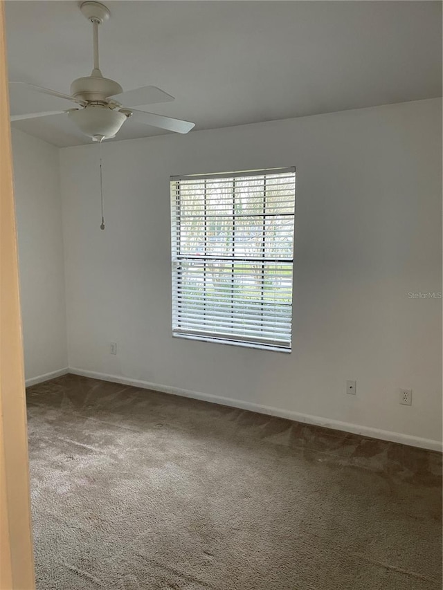 carpeted empty room featuring ceiling fan