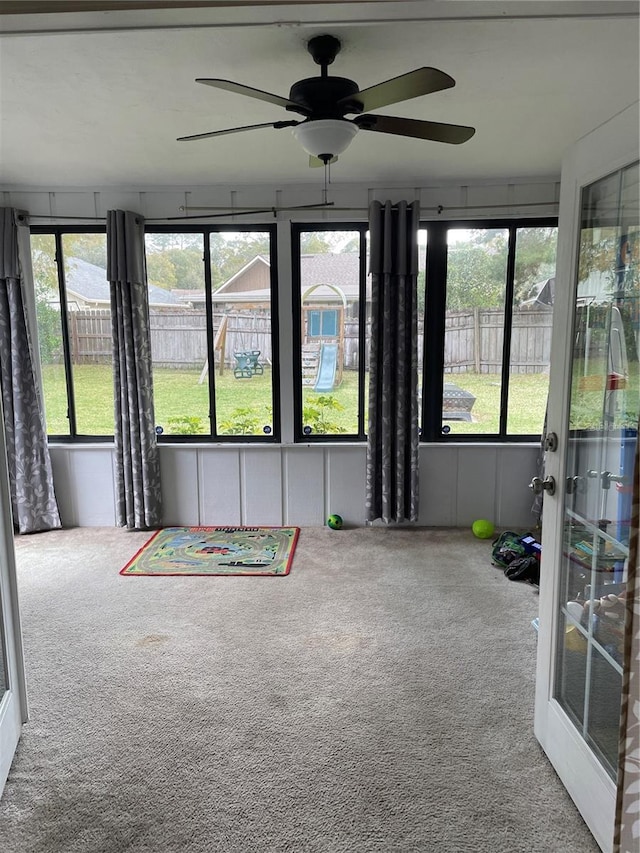 unfurnished sunroom with ceiling fan and a healthy amount of sunlight