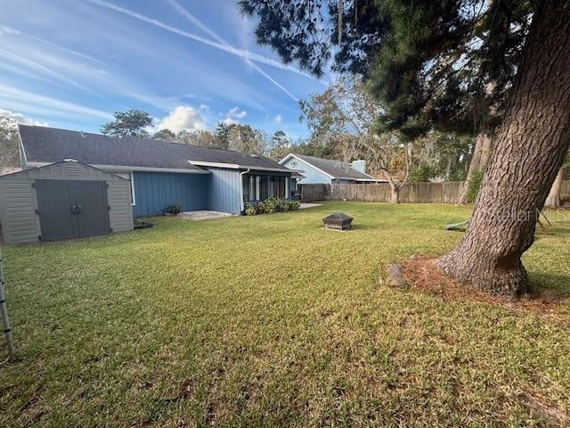 view of yard with a shed and an outdoor fire pit