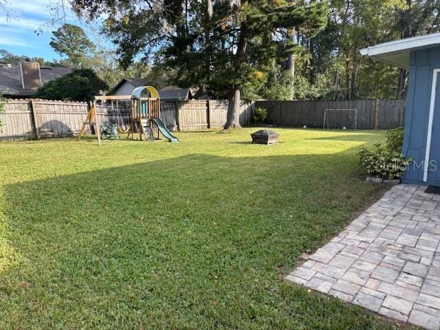 view of yard with a playground and an outdoor fire pit