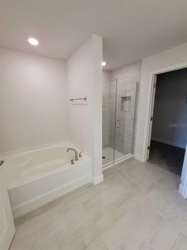 bathroom featuring plus walk in shower and tile patterned flooring