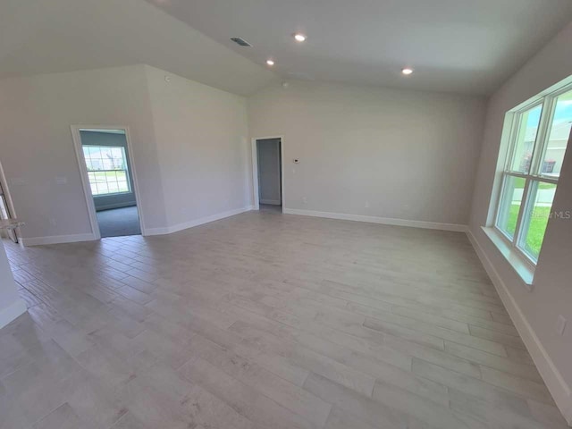empty room with recessed lighting, baseboards, visible vents, vaulted ceiling, and light wood-type flooring