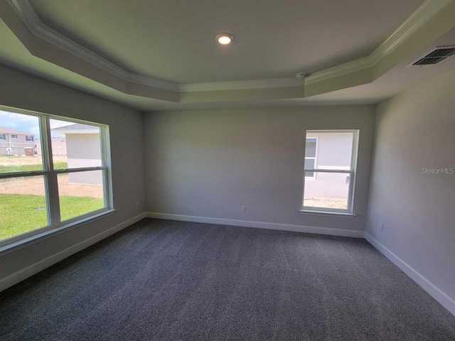 unfurnished room with a raised ceiling, visible vents, and crown molding