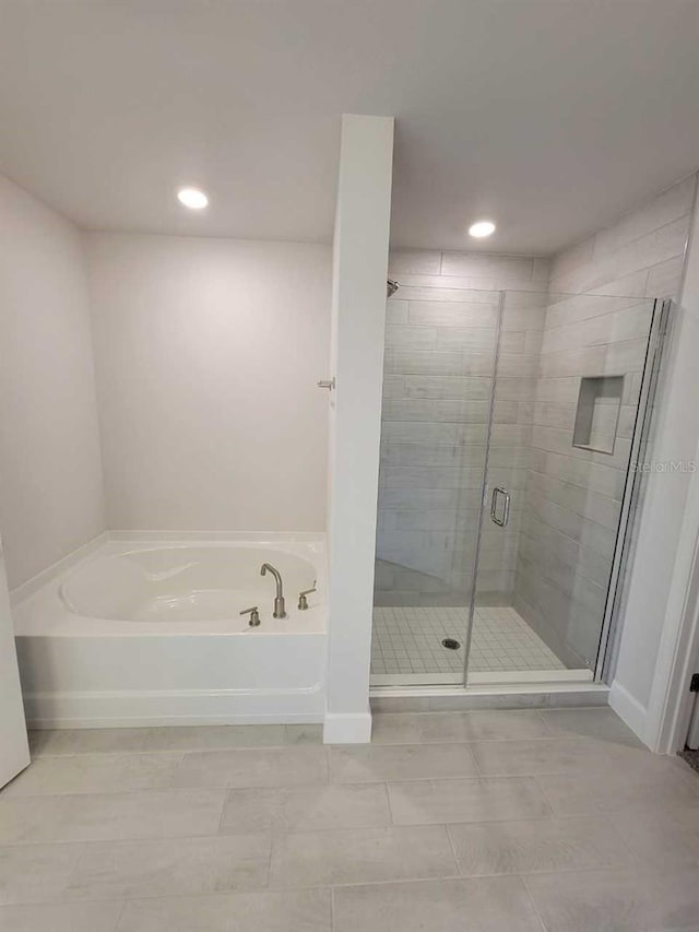 full bathroom featuring a stall shower, baseboards, a garden tub, and recessed lighting