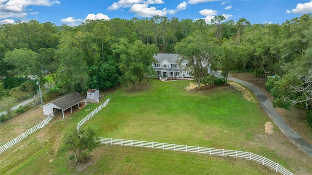 birds eye view of property featuring a rural view and a wooded view