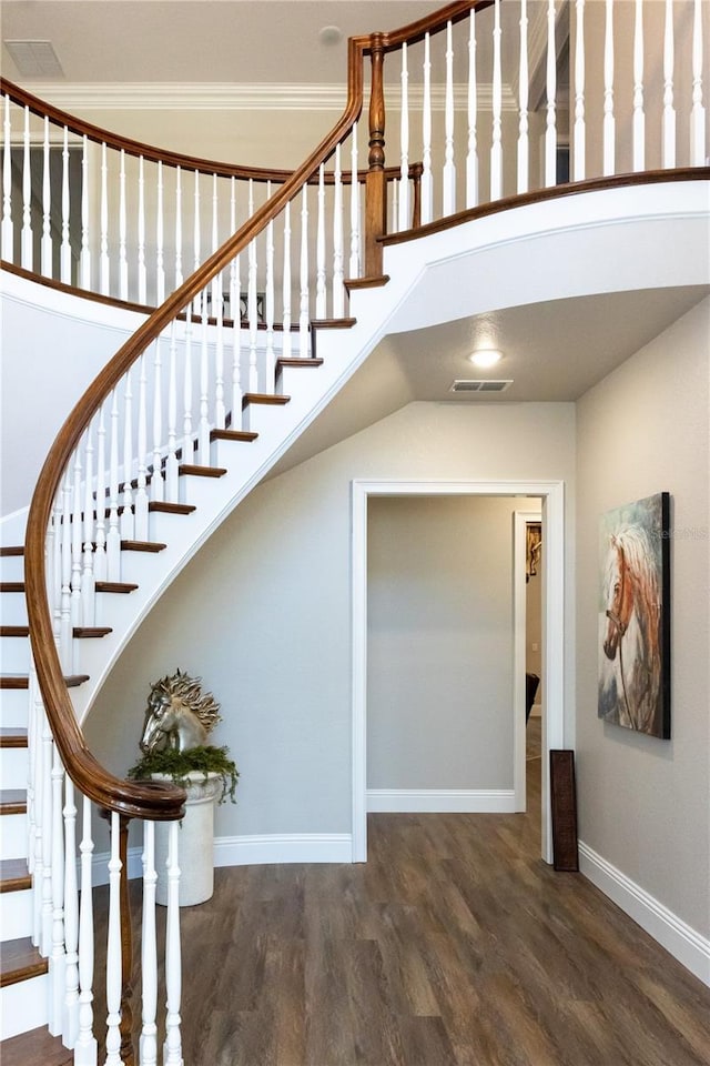 staircase featuring wood finished floors, visible vents, and baseboards