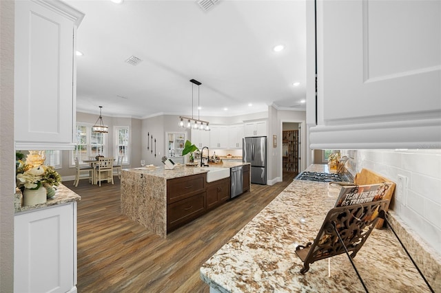 kitchen featuring visible vents, dark wood-style floors, appliances with stainless steel finishes, crown molding, and a chandelier