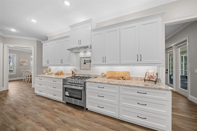 kitchen featuring stainless steel stove, white cabinets, crown molding, and under cabinet range hood