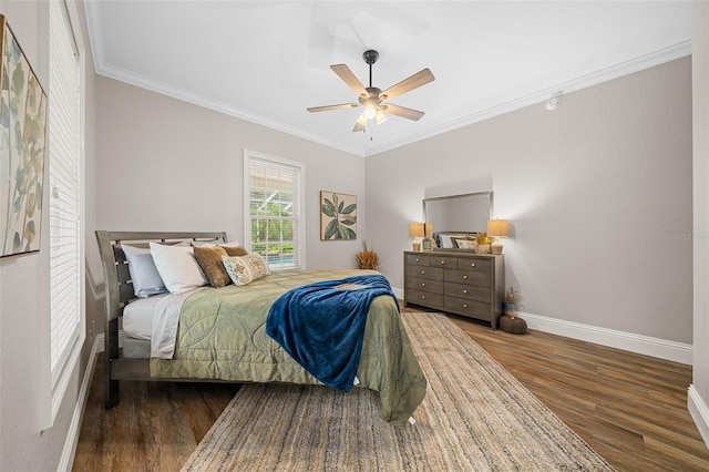 bedroom with baseboards, a ceiling fan, wood finished floors, and crown molding