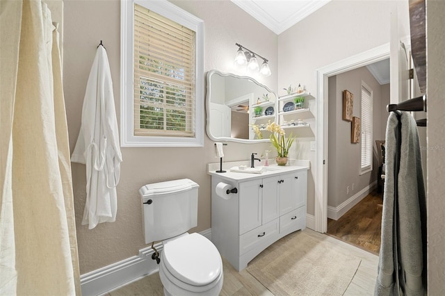 full bathroom with vanity, wood finished floors, baseboards, crown molding, and toilet