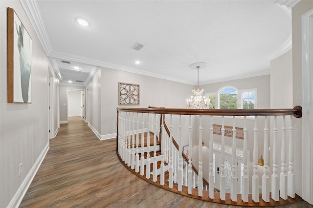 corridor featuring visible vents, an upstairs landing, wood finished floors, crown molding, and baseboards