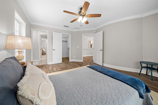 bedroom featuring visible vents, wood finished floors, baseboards, and ornamental molding