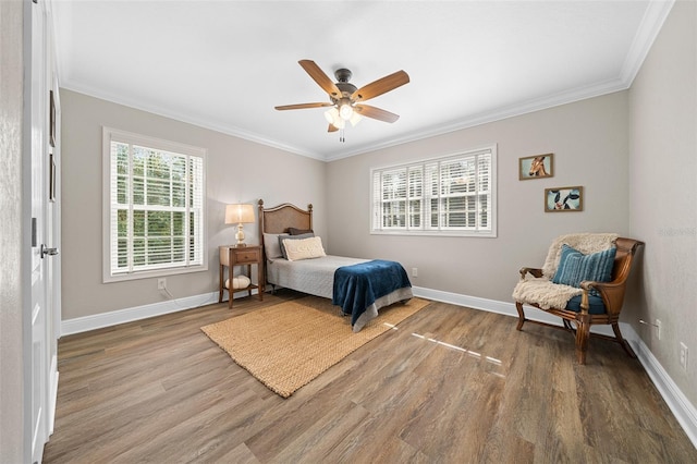 bedroom with wood finished floors, baseboards, and ornamental molding