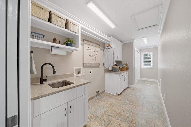 clothes washing area featuring electric dryer hookup, a sink, cabinet space, crown molding, and hookup for a washing machine