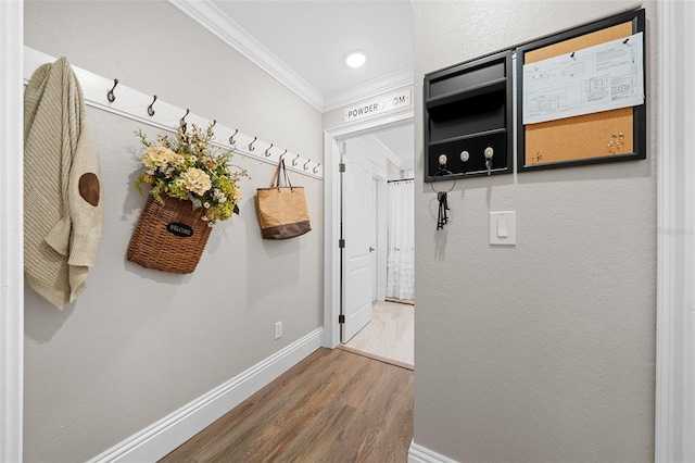 corridor featuring wood finished floors, baseboards, and ornamental molding