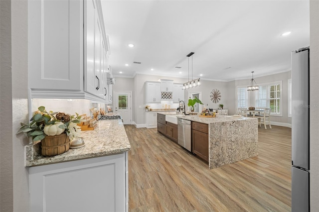 kitchen featuring stainless steel appliances, backsplash, light wood-style flooring, and crown molding