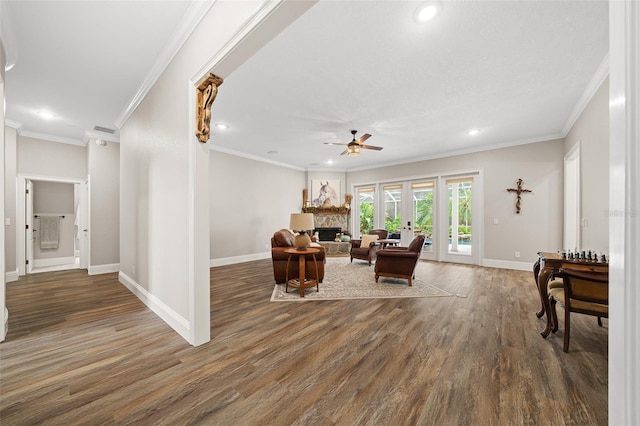 living area with ceiling fan, baseboards, wood finished floors, and a fireplace