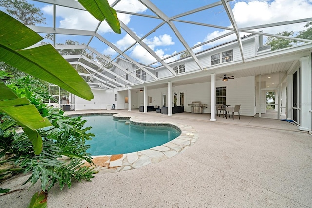 outdoor pool featuring glass enclosure, a patio, a ceiling fan, and grilling area