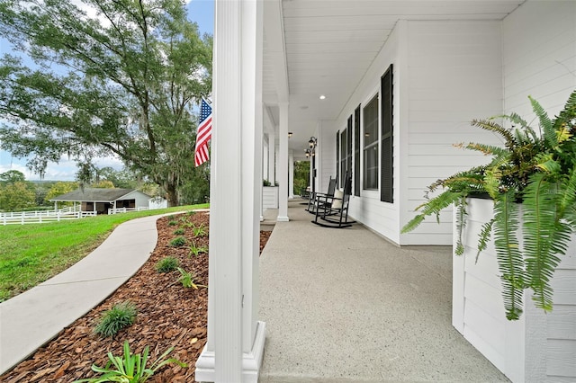 view of patio / terrace featuring a porch and fence