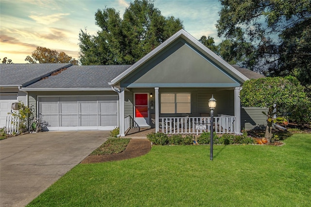 ranch-style home featuring covered porch, a yard, and a garage