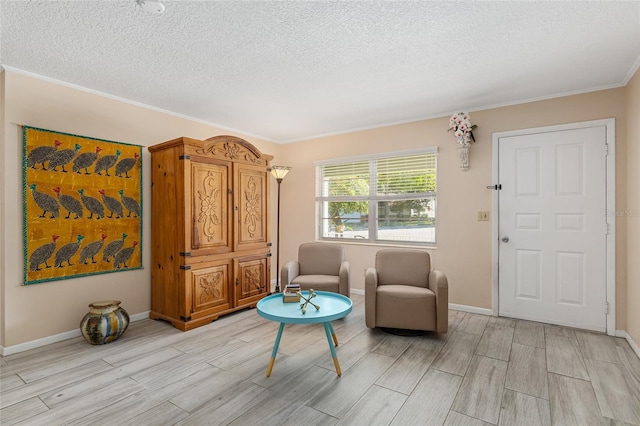 sitting room with a textured ceiling and crown molding