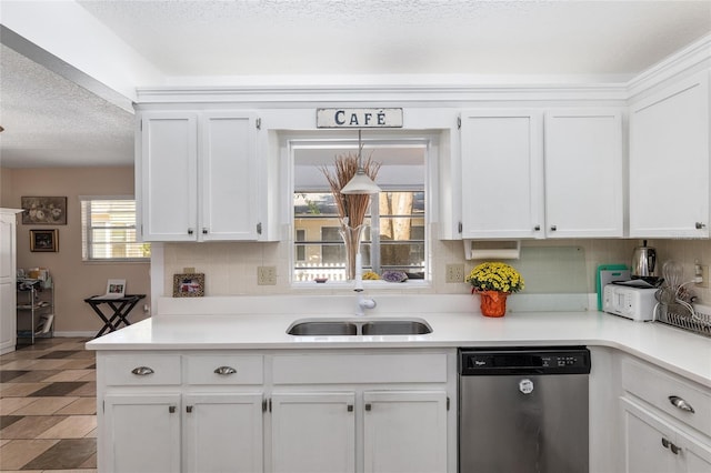 kitchen featuring backsplash, white cabinets, sink, stainless steel dishwasher, and a textured ceiling