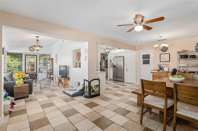 interior space with a textured ceiling and ceiling fan with notable chandelier