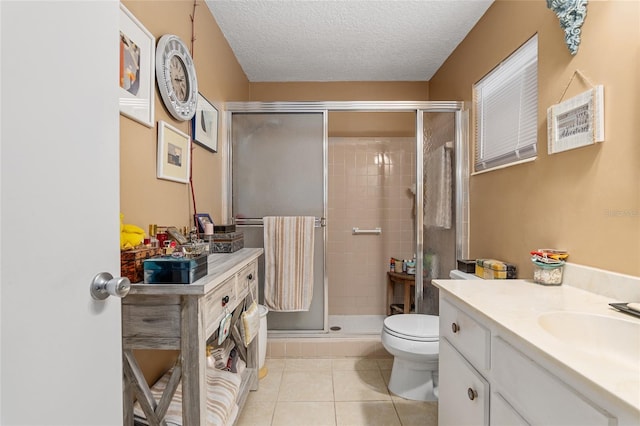 bathroom with tile patterned flooring, a textured ceiling, toilet, and a shower with shower door