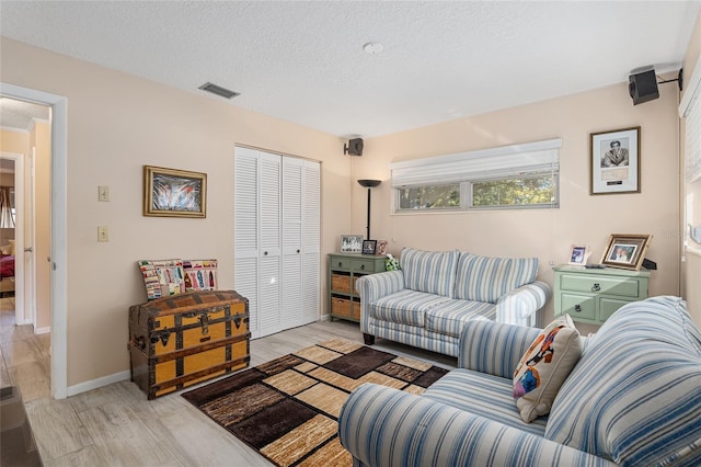 living room with a textured ceiling and light hardwood / wood-style flooring