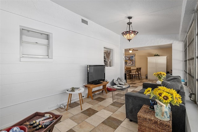 living room featuring lofted ceiling and a textured ceiling