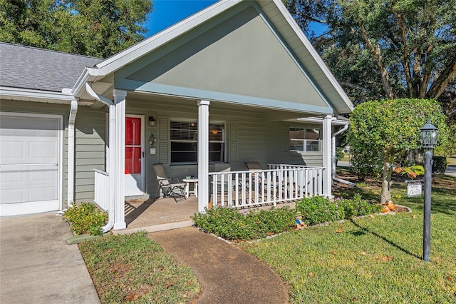 view of front of property with a porch, a front yard, and a garage