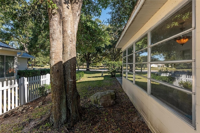 view of yard with a sunroom and a water view