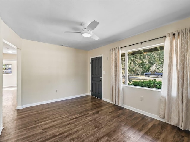 empty room with ceiling fan and dark wood-type flooring