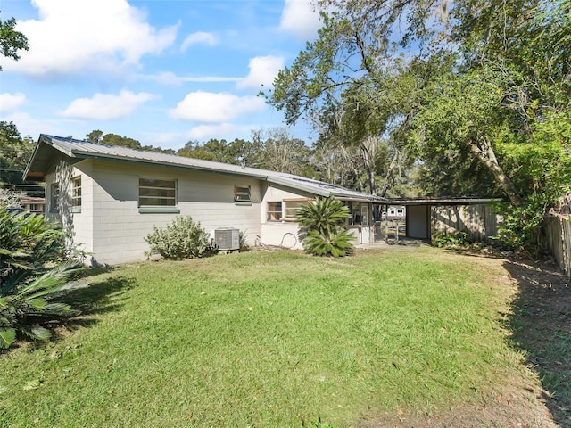 rear view of property featuring a yard and central AC unit