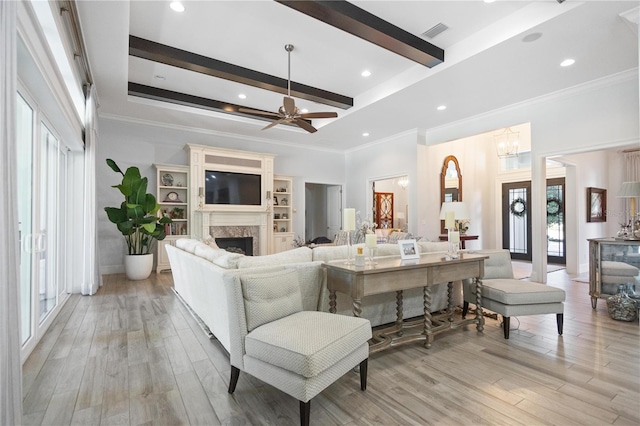 living room featuring ceiling fan with notable chandelier, beam ceiling, ornamental molding, and light hardwood / wood-style flooring