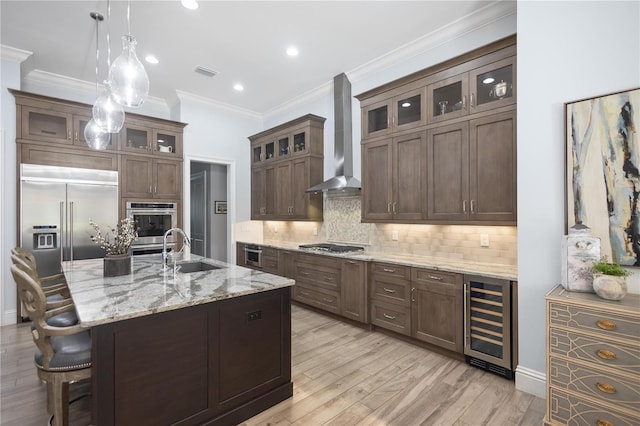 kitchen featuring light stone countertops, sink, wall chimney range hood, wine cooler, and light wood-type flooring