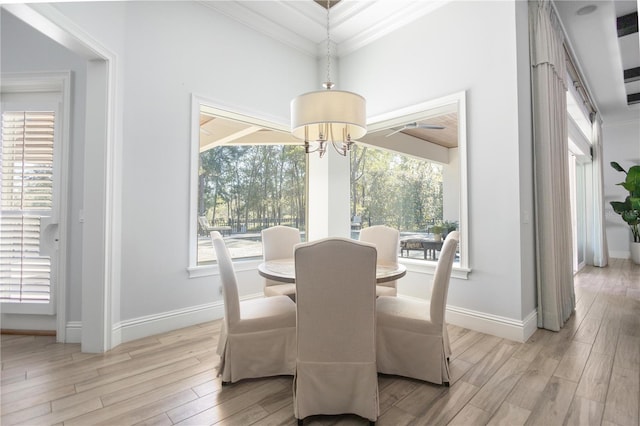 dining space featuring a chandelier, light wood-type flooring, a wealth of natural light, and crown molding