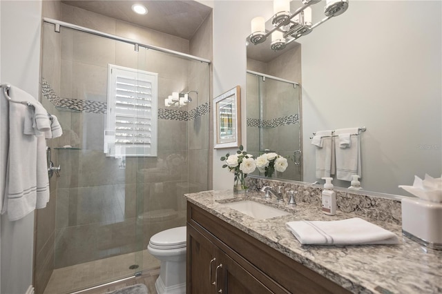 bathroom with vanity, an enclosed shower, and toilet