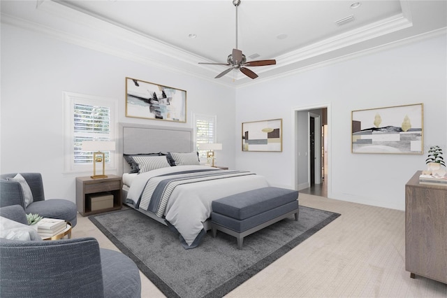 carpeted bedroom featuring ceiling fan, ornamental molding, and a tray ceiling