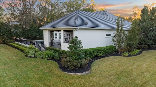 property exterior at dusk with a yard