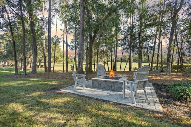 yard at dusk featuring a patio and an outdoor fire pit