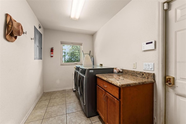 washroom featuring light tile patterned floors, washing machine and dryer, and electric panel