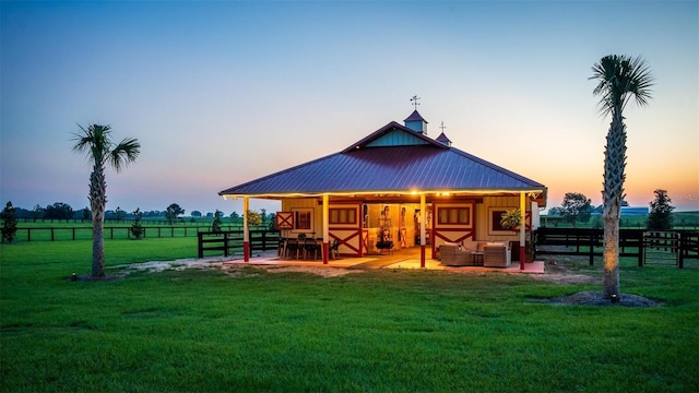 back house at dusk featuring central AC unit and an outdoor structure