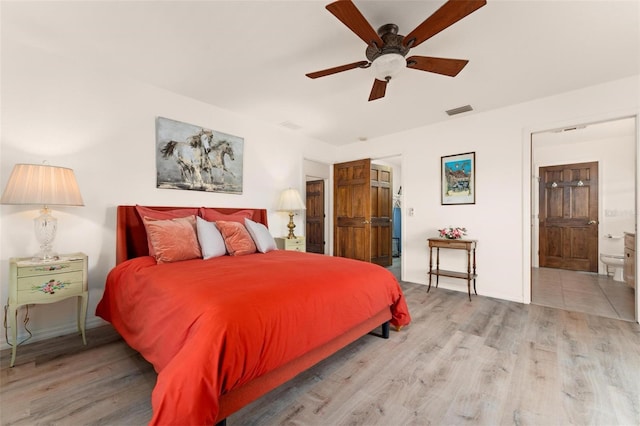 bedroom with ceiling fan, light wood-type flooring, and connected bathroom