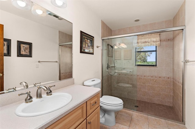 bathroom with toilet, vanity, tile patterned floors, and a shower with door