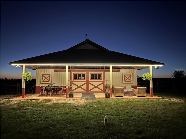 back house at dusk with a lawn and an outdoor hangout area