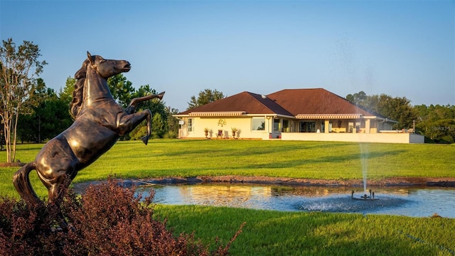 view of home's community with a lawn and a water view