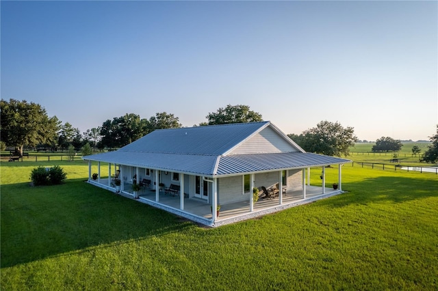 rear view of property with a patio, a rural view, and a lawn