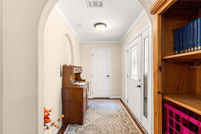 entryway with a textured ceiling and ornamental molding