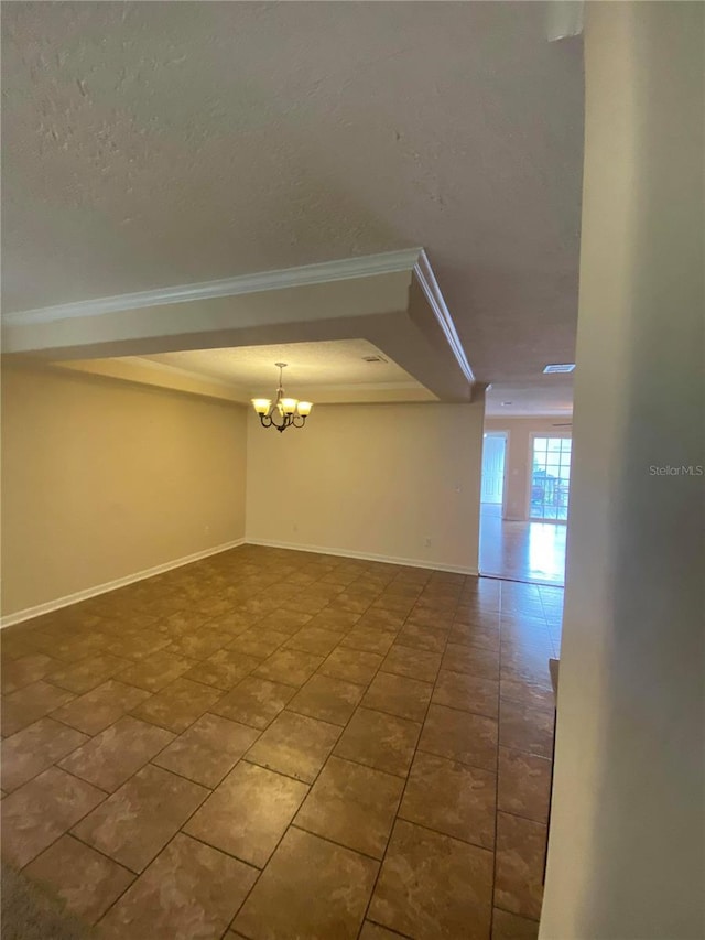 empty room featuring tile patterned floors, crown molding, a chandelier, and a textured ceiling